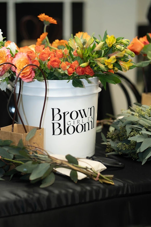 Orange florals in a Brown Girl en Bloom bucket during the activation