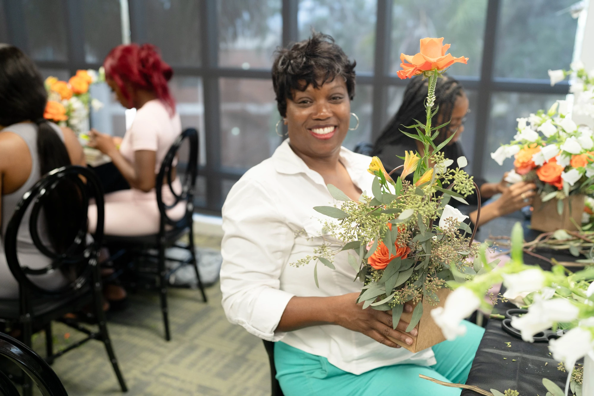 A guest holding her completed floral arrangement