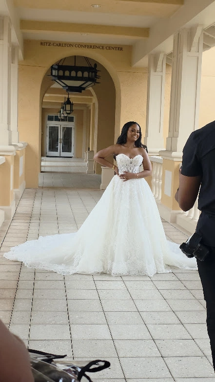 A bride in a white lace gown beneath the Ritz-Carlton conference center archway